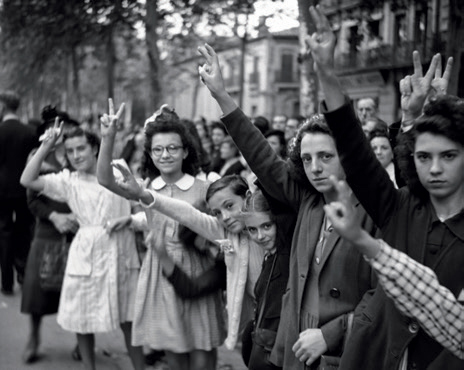 Un groupe de personnes lève le bras en faisant le signe de la victoire 